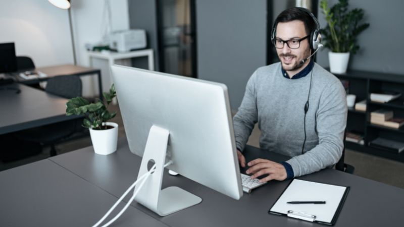 Man in front of computer with headset Eigenbestandsverwalter