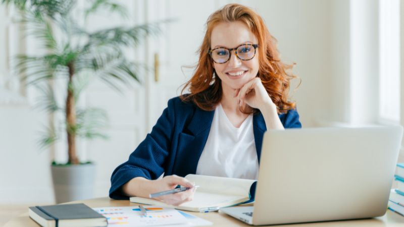 Frau mit Laptop in Büò